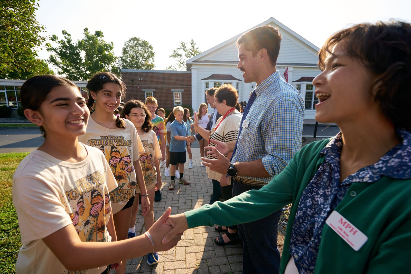 line of smiling students and teachers
